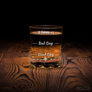 Dodatkowe zdjęcie nr 3 - pełna szklanka do whisky stojąca na drewnianym blacie.