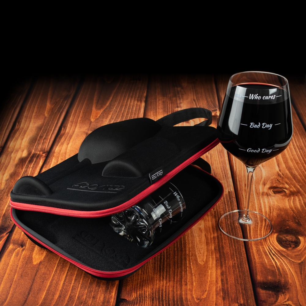 Uchylone etui ze szklanką w środku oraz gigantyczny kieliszek pełen wina stojący po prawej.